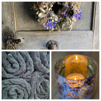 Welcome im Wohlfühlraum mit Holztür und Blumenkranz, gerollter flauschiger Frotteewäsche und Kerzenlicht